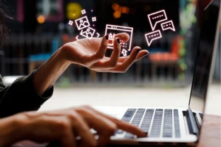 A person interacts with a laptop, displaying various icons and a focus on digital interaction.